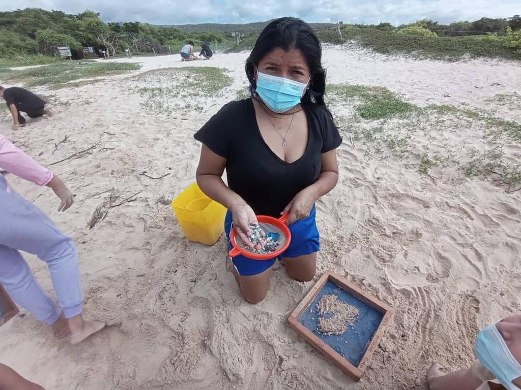 Maira Hernández en la playa recogiendo plásticos