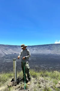 Park ranger Danny Garcia diligently collects precipitation data from within the confines of Wolf Volcano's crater.