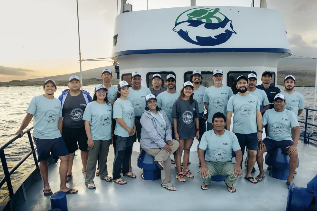 After successfully completing their mission to monitor the pinnipeds of Galápagos, the team of researchers, scientists, and park rangers smiles in satisfaction.