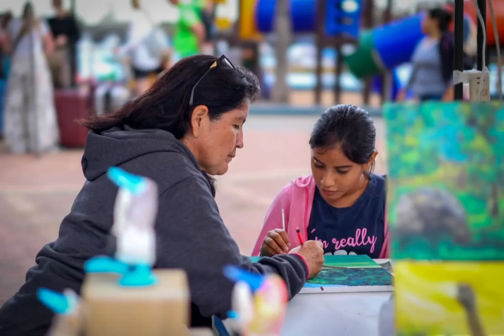 Geovanna Morales teaches a young student to paint, combining art with environmental education to inspire new generations in the Galápagos.