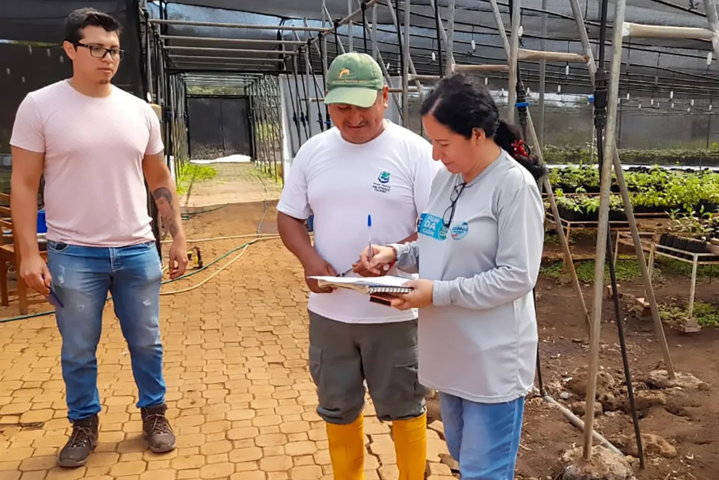 Grace Unda receives plants from a park ranger for the restoration of the water source at Cerro Gato