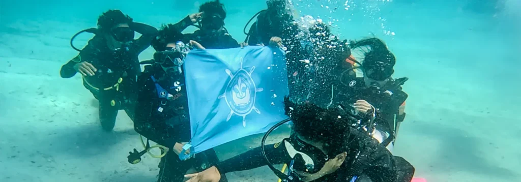 Scouts with their flag underwater in the Galapagos Ocean