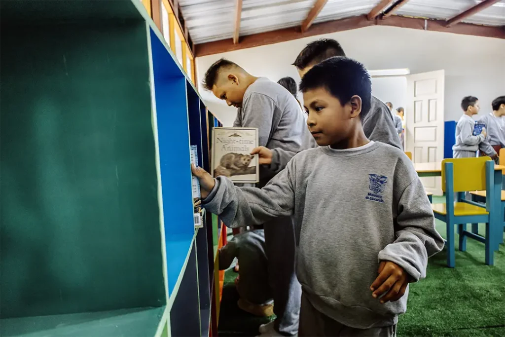 Students from Unidad Educativa Amazonas on Floreana Island place the first books on the shelves of their new library, opening a gateway to learning and discovery.