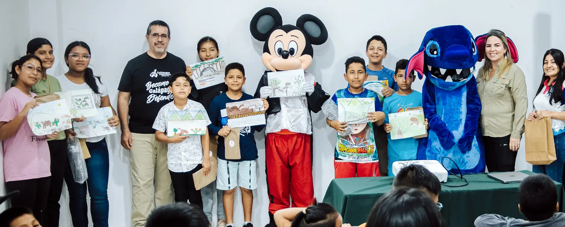 Students from Floreana showcase creative works on giant tortoise conservation, joined by Washington Tapia and Jenny Macías from Galápagos Conservancy.